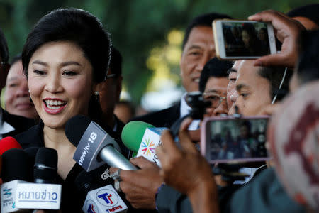 Ousted former Thai Prime Minister Yingluck Shinawatra speaks with members of Thai media as she arrives at the Supreme Court for a trial on criminal negligence looking into her role in a debt-ridden rice subsidy scheme during her administration, in Bangkok, Thailand December 9, 2016. REUTERS/Chaiwat Subprasom