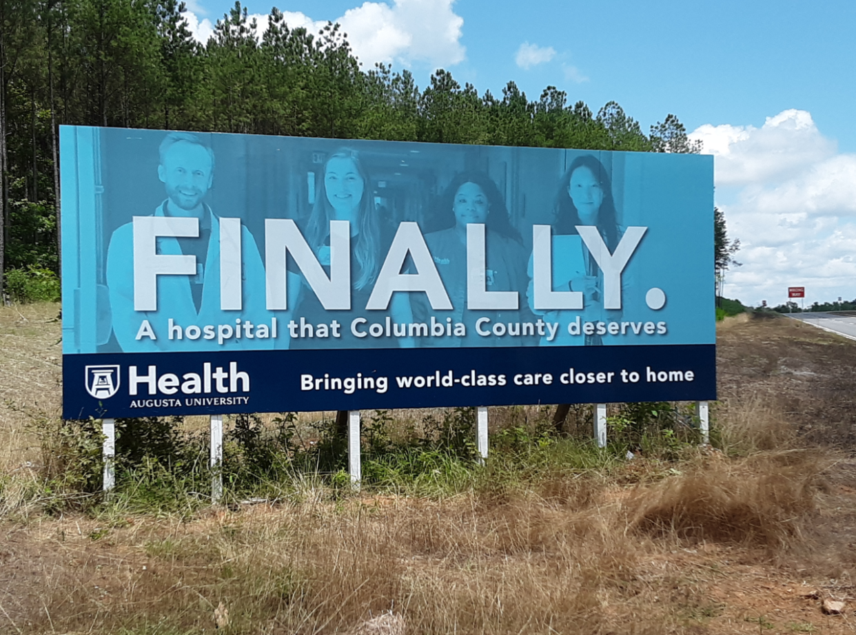 FILE - AU Health billboard at the future site of its 100-bed hospital in Columbia County. AU Health is facing a downgrade in its bond rating must as construction on the new hospital is gearing up.