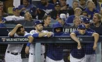 Some Los Angeles Dodgers watch from the dugout during the ninth inning of Game 3 of the National League Championship Series baseball game against the Milwaukee Brewers Monday, Oct. 15, 2018, in Los Angeles. (AP Photo/Matt Slocum)