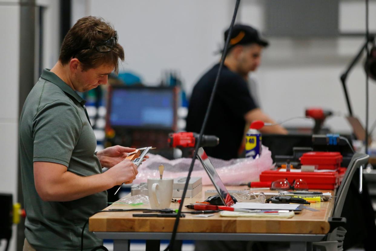 Jordan Fernandes measures a recently manufactured part at the new Proto XYZ manufacturing facilty on Potomska Street in New Bedford.