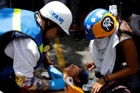 An injured man receives help during a strike called to protest against Venezuelan President Nicolas Maduro's government in Caracas, Venezuela July 26, 2017. REUTERS/Carlos Garcia Rawlins