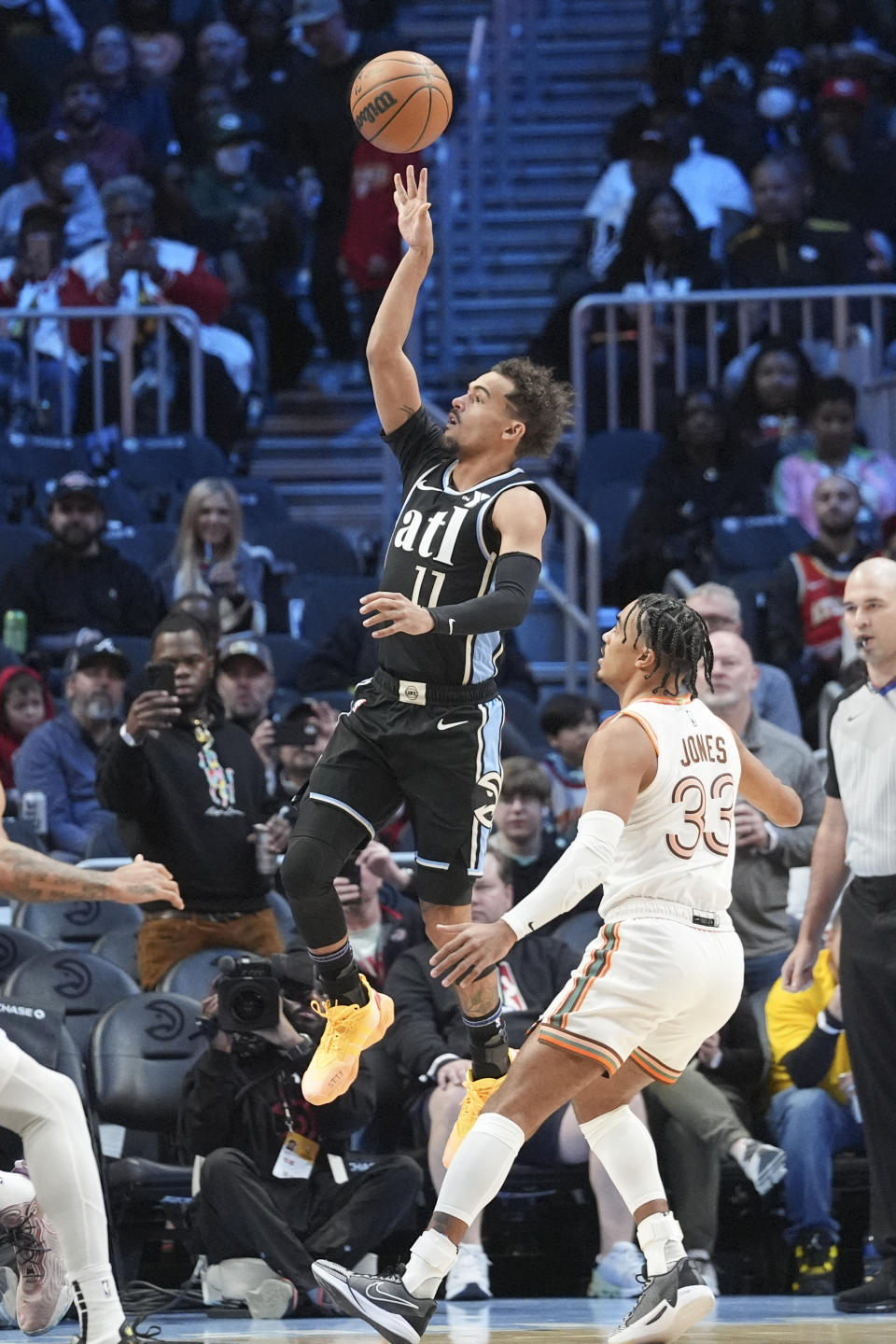 Atlanta Hawks guard Trae Young (11) shoots as San Antonio Spurs guard Tre Jones (33) looks one during the first half of an NBA basketball game Monday, Jan. 15, 2024, in Atlanta. (AP Photo/John Bazemore)