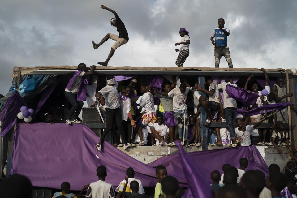 Supporters of the presidential candidate Kouadio Konan Bertin, dance over a sound truck during the final campaign rally in Abidjan, Ivory Coast, Thursday, Oct. 29, 2020. Bertin, known as KKB, has presented his candidacy as an independent candidate for the upcoming Oct. 31 election, and said he would not join the boycott proposed by two main opponents of Ivory Coast President Alassane Ouattara. (AP Photo/Leo Correa)
