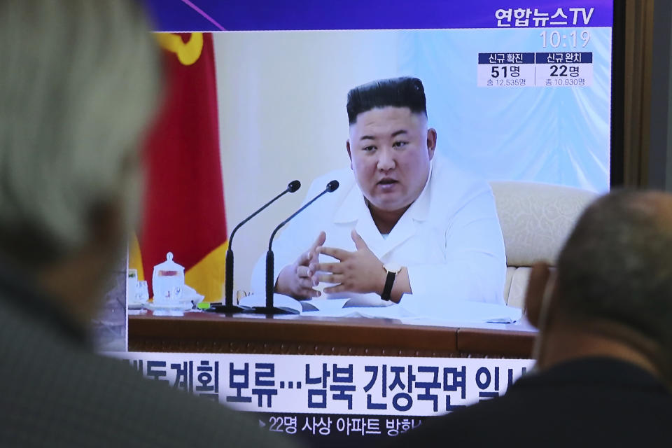 People watch a TV showing a file image of North Korean leader Kim Jong Un during a news program at the Seoul Railway Station in Seoul, South Korea, Wednesday, June 24, 2020. Kim suspended his military's plans to take unspecified retaliatory action against South Korea, state media said Wednesday, possibly slowing a pressure campaign against its rival amid stalled nuclear negotiations with the Trump administration. The Korean letters read: "Kim suspended military's plans." (AP Photo/Ahn Young-joon)