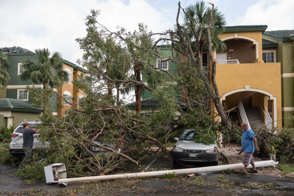 Residents at Sanctuary Cove take in the damage in the aftermath of a Saturday evening tornado on Sunday, April 30, 2023, in North Palm Beach, Fla. The National Weather Service confirmed an EF-1 tornado touched down in Palm Beach Gardens Saturday evening.