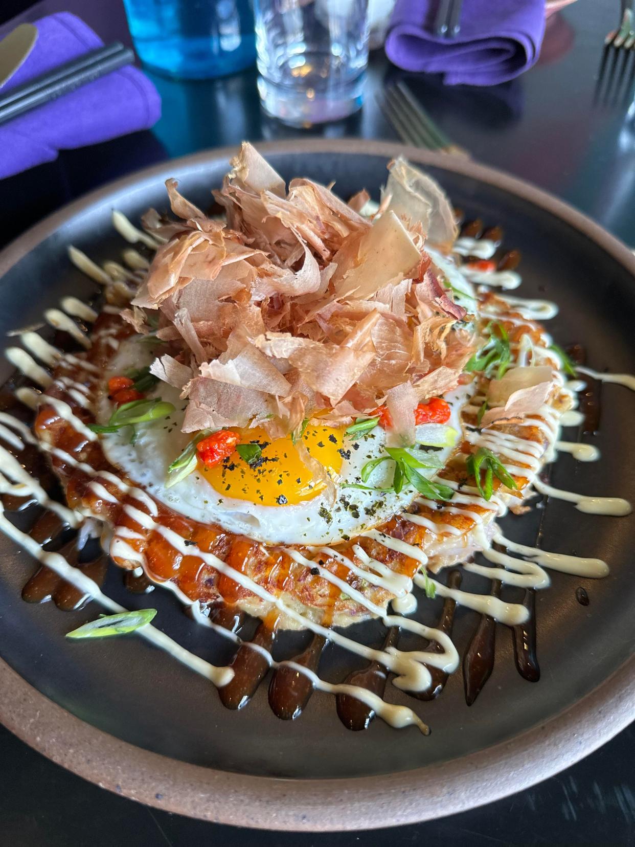 RosaBees' new brunch menu features the Brekkie Okonomiyaki, a savory Japanese street food cabbage pancake with wild red shrimp, two sunny eggs, scallion, Kewpie mayo, house Okonomi sauce, bonito flake and chili crisp.