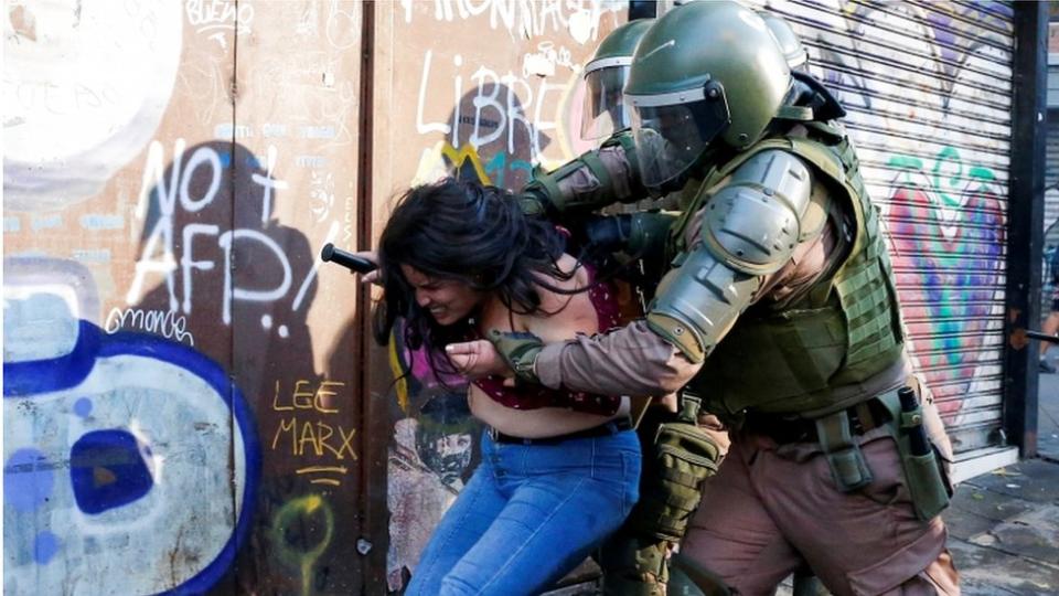 Mujer arrestada durante las protestas en Chile