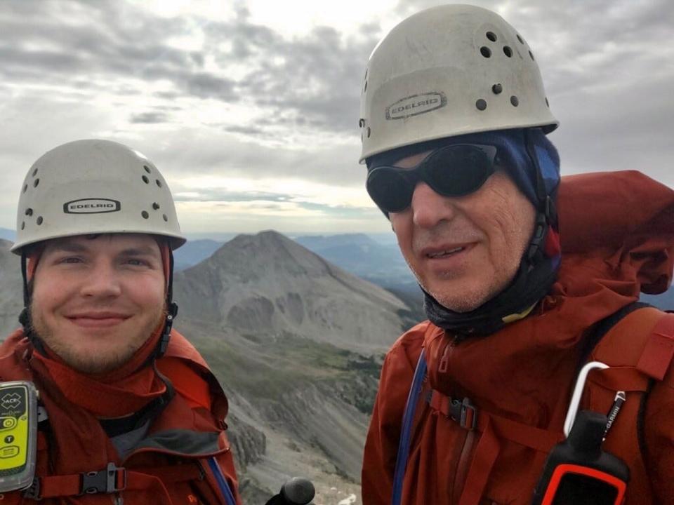Craig Brauer, 65, right, is pictured with his son, Josh, 33 as they summit Capitol Peak in Colorado on July 18, 2022. Craig Brauer said his son once saved him after he became trapped in a narrow gully of snow.