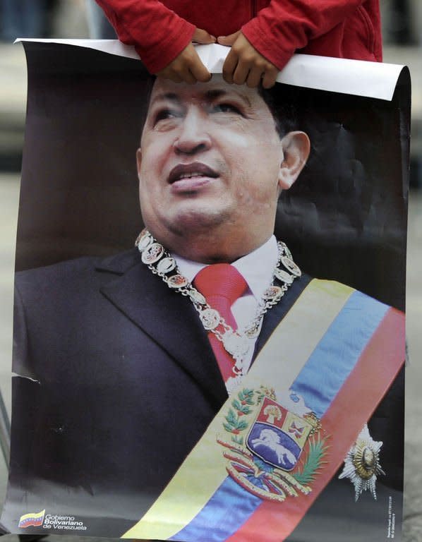 A boy holds a poster of Venezuelan President Hugo Chavez as the leader's supporters gather at Simon Bolivar Square in Caracas on February 18, 2013. Even as passionate supporters took to the streets in noisy celebration, and foreign dignitaries sent congratulations and urged Chavez to rest, the next step for the oil-rich country and its colorful leader remained unclear