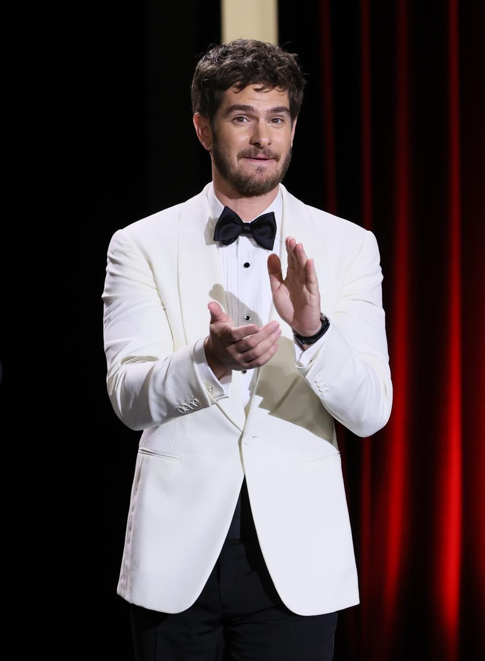 Andrew Garfield claps on stage