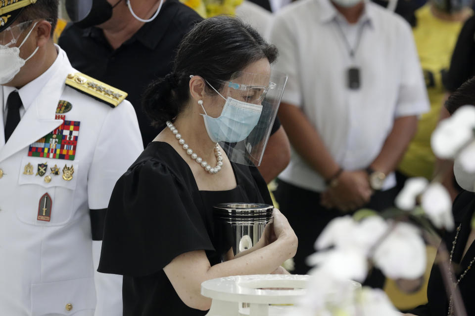 Ballsy Aquino-Cruz, embraces the urn of her brother former Philippine President Benigno Aquino III before he is placed in the tomb during state burial rites on Saturday, June 26, 2021 at a memorial park in suburban Paranaque city, Philippines. Aquino was buried in austere state rites during the pandemic Saturday with many remembering him for standing up to China over territorial disputes, striking a peace deal with Muslim guerrillas and defending democracy in a Southeast Asian nation where his parents helped topple a dictator. He was 61. (AP Photo/Aaron Favila)