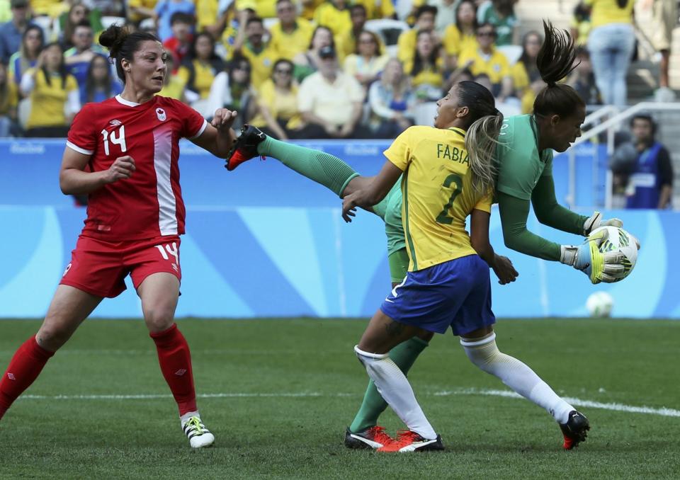 <p>Barbara (BRA) of Brazil makes a save as Fabiana (BRA) of Brazil and Melissa Tancredi (CAN) of Canada look on. (Reuters) </p>