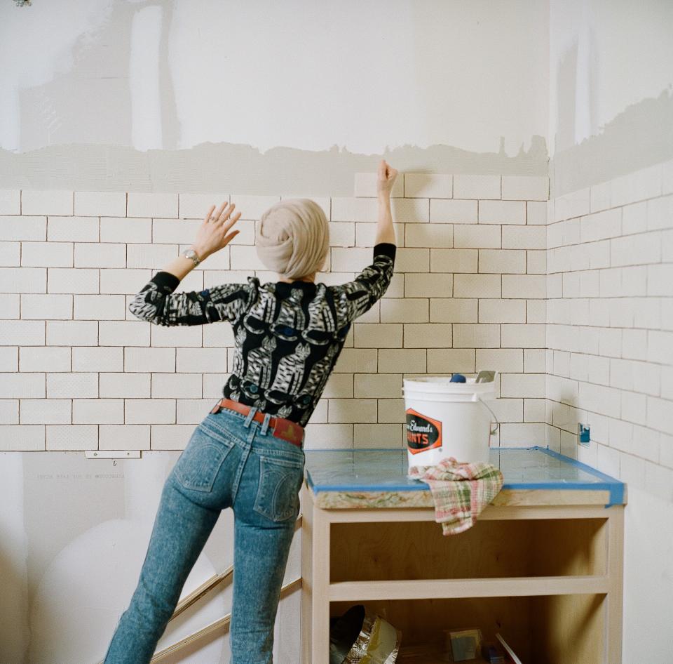 The author helping to install subway tiles in the space.