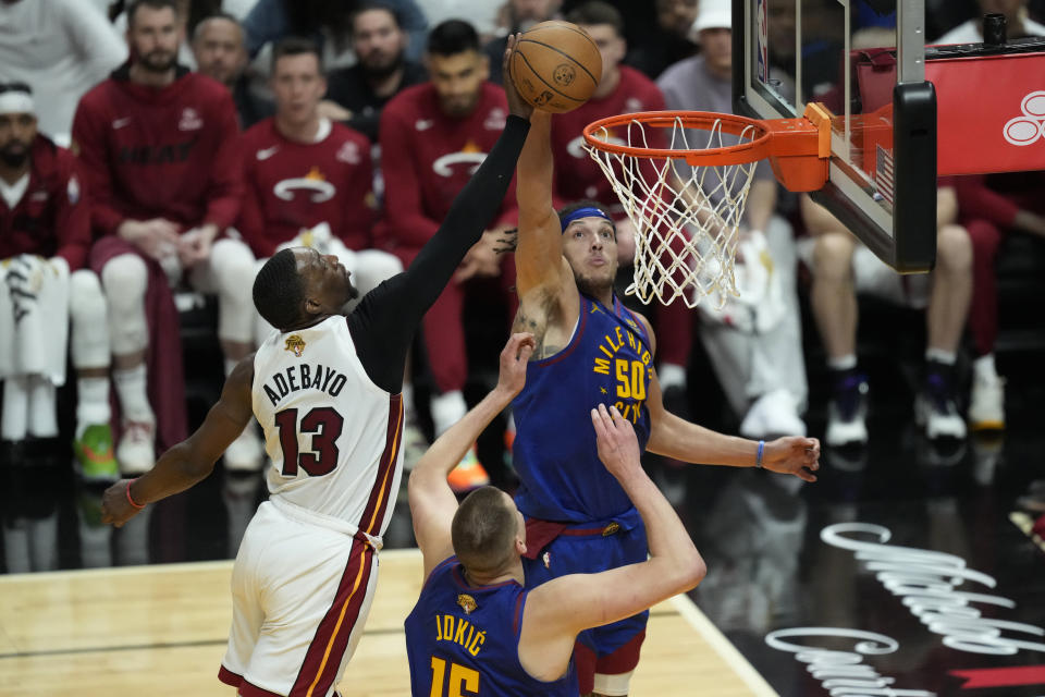 Miami Heat center Bam Adebayo (13) drives to the basket as Denver Nuggets forward Aaron Gordon (50) defends during the first half of Game 3 of the NBA Finals basketball game, Wednesday, June 7, 2023, in Miami. (AP Photo/Rebecca Blackwell)
