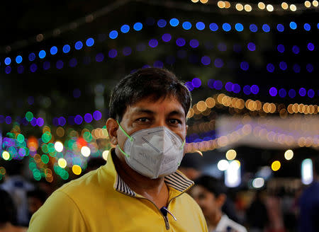 A man wearing a mask looks on as he walks in a market in New Delhi, India, November 6, 2018. REUTERS/Anushree Fadnavis