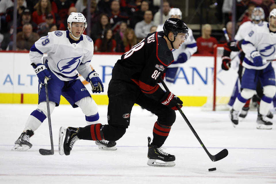 Carolina Hurricanes' Martin Necas (88) controls the puck in front of Tampa Bay Lightning's Ross Colton (79) during the first period of an NHL hockey game in Raleigh, N.C., Tuesday, March 28, 2023. (AP Photo/Karl B DeBlaker)