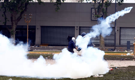 A protester throws back a tear gas canister at the police during clashes outside the Congress, where the budget bill is being debated, in Buenos Aires, Argentina October 24, 2018. REUTERS/Martin Acosta