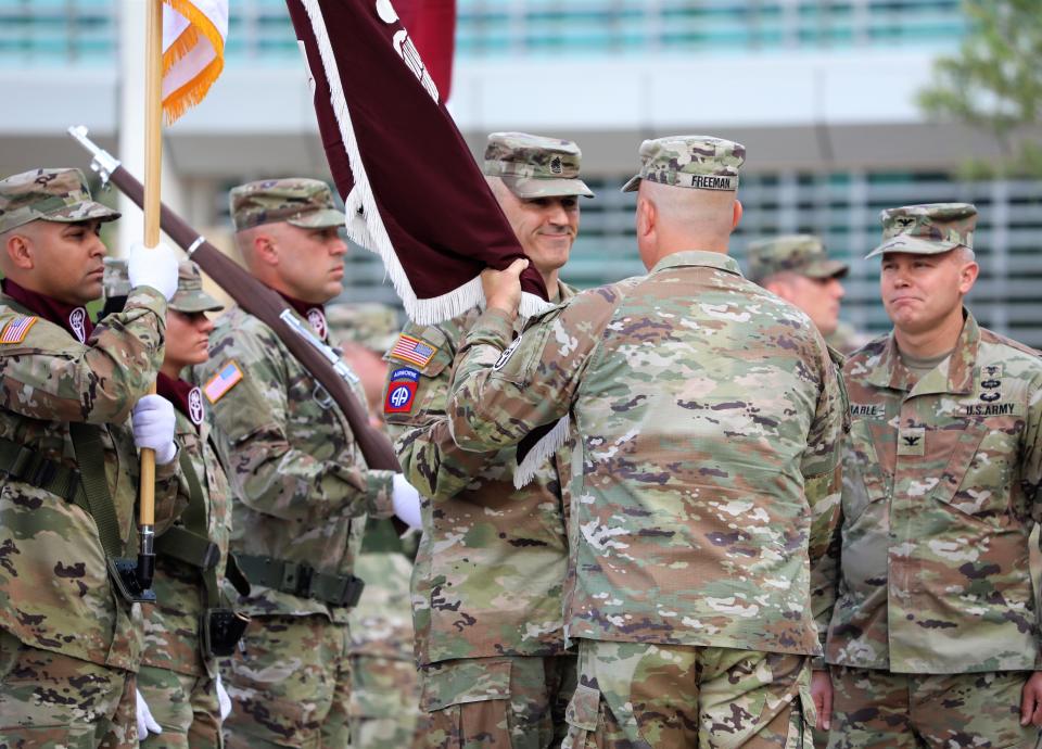 Army Col. Lee Freeman gives the William Beaumont Army Medical Center flag to Command Sgt. Maj. James Ian Musnicki, the hospital's senior enlisted adviser, during the change of command ceremony Thursday outside the Fort Bliss medical complex in East El Paso. Freeman is the hospital's new commander. Army Col. Brett Venable, right, the outgoing commander, looks on.