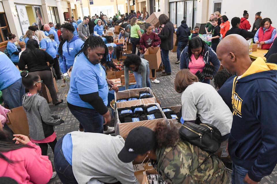 MLK Day of Service volunteers participate in the project at McAlister Square in Greenville Monday. Co-sponsor employees from Duke Energy, TD Bank packed bags of items for homeless, along with community volunteers and J.L. Mann High School basketball players. Several Greenville agencies will distribute to homeless.