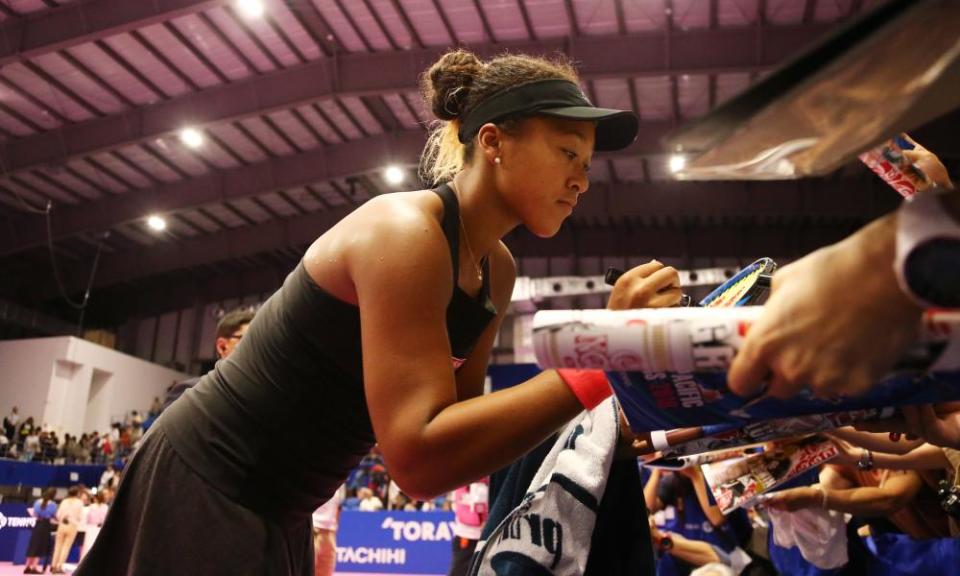 Naomi Osaka signs autographs for fans after her victory over Dominika Cibulkova at the Pan Pacific Open
