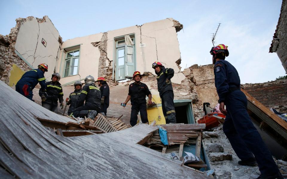 Firefighters search for survivors in the wreckage of a collapsed house in the village of Vrissas on Lesbos. - Credit: EPA