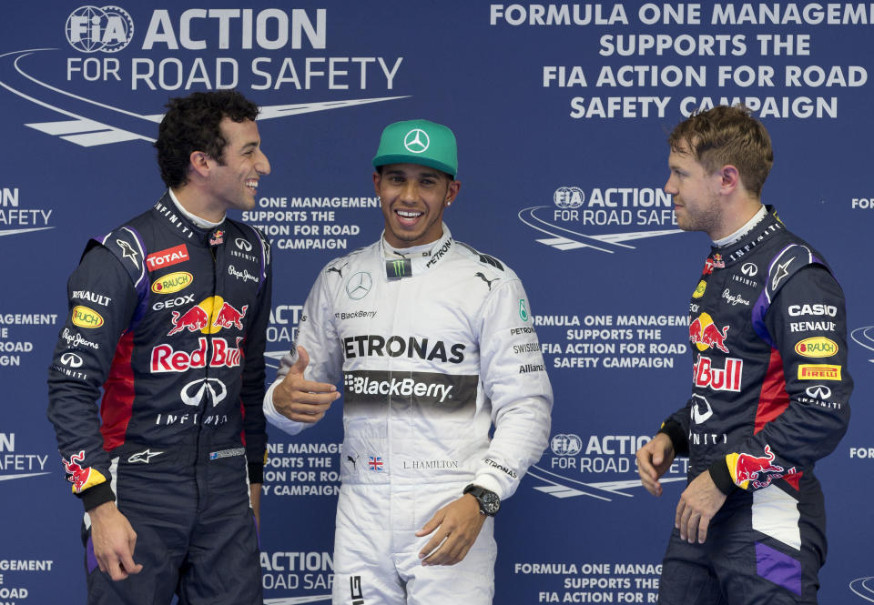 Red Bull Racing driver Daniel Ricciardo of Australia, left, Mercedes driver Lewis Hamilton of Britain, center, and Red Bull Racing driver Sebastian Vettel of Germany, right, chat after the qualifying session of the Chinese Formula One Grand Prix at Shanghai International Circuit in Shanghai, Saturday, April 19, 2014. (AP Photo/Andy Wong)