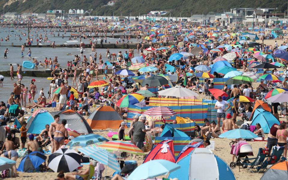 Sunbathers on Bournemouth beach in Dorset - PA