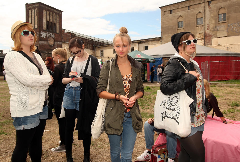 BERLIN, GERMANY - JULY 21: Attendees wait to get their faces painted with glitter at the second annual Hipster Olympics on July 21, 2012 in Berlin, Germany. With events such as the "Horn-Rimmed Glasses Throw," "Skinny Jeans Tug-O-War," "Vinyl Record Spinning Contest" and "Cloth Tote Sack Race," the Hipster Olympics both mocks and celebrates the Hipster subculture, which some critics claim could never be accurately defined and others that it never existed in the first place. The imprecise nature of determining what makes one a member means that the symptomatic elements of adherants to the group vary in each country, but the archetype of the version in Berlin, one of the more popular locations for those following its lifestyle, along with London and Brooklyn, includes a penchant for canvas tote bags, the carbonated yerba mate drink Club Mate, analogue film cameras, an asymetrical haircut, 80s neon fashion, and, allegedly, a heavy dose of irony. To some in Berlin, members of the hipster "movement" have replaced a former unwanted identity in gentrifying neighborhoods, the Yuppie, for targets of criticism, as landlords raise rents in the areas to which they relocate, particularly the up-and-coming neighborhood of Neukoelln. (Photo by Adam Berry/Getty Images)