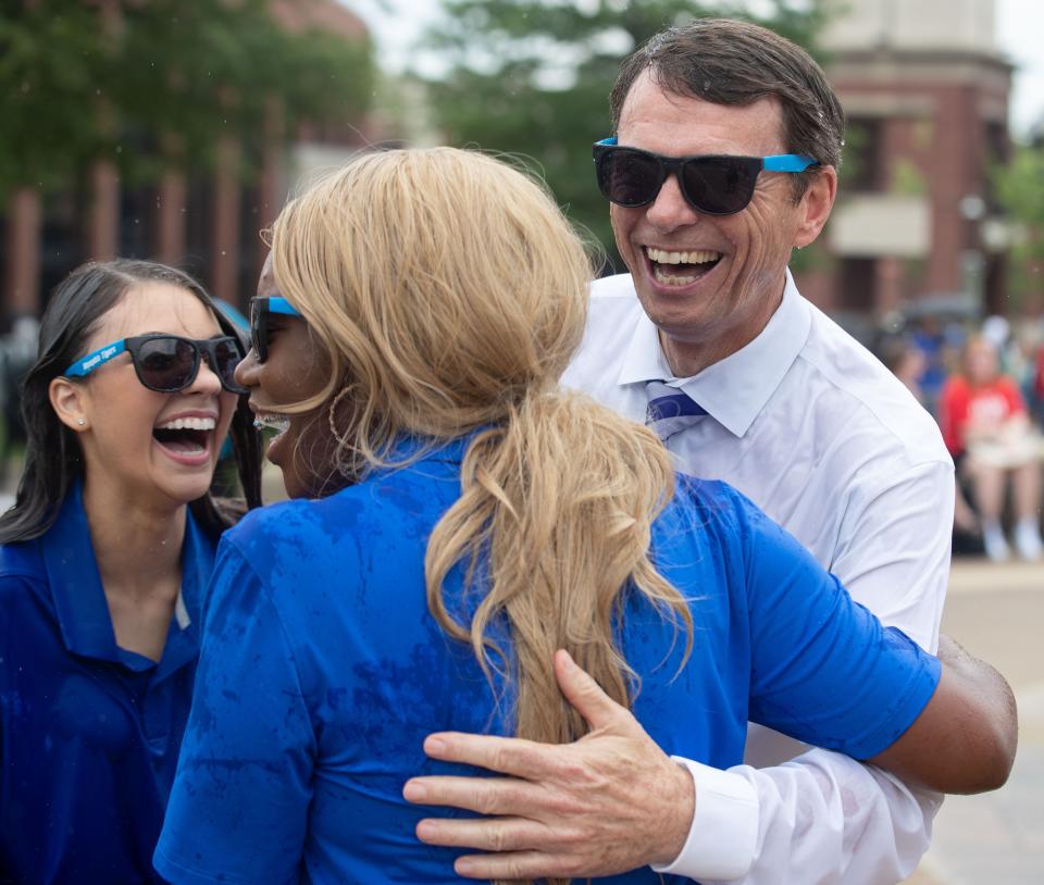 Memphis President Bill Hardgrave hugs Student Government President Atlantica Smith, front, and Student Government Vice President Ansley Ecker, back, after running through the campus fountain Monday, Aug. 22, 2022, at the University of Memphis. 