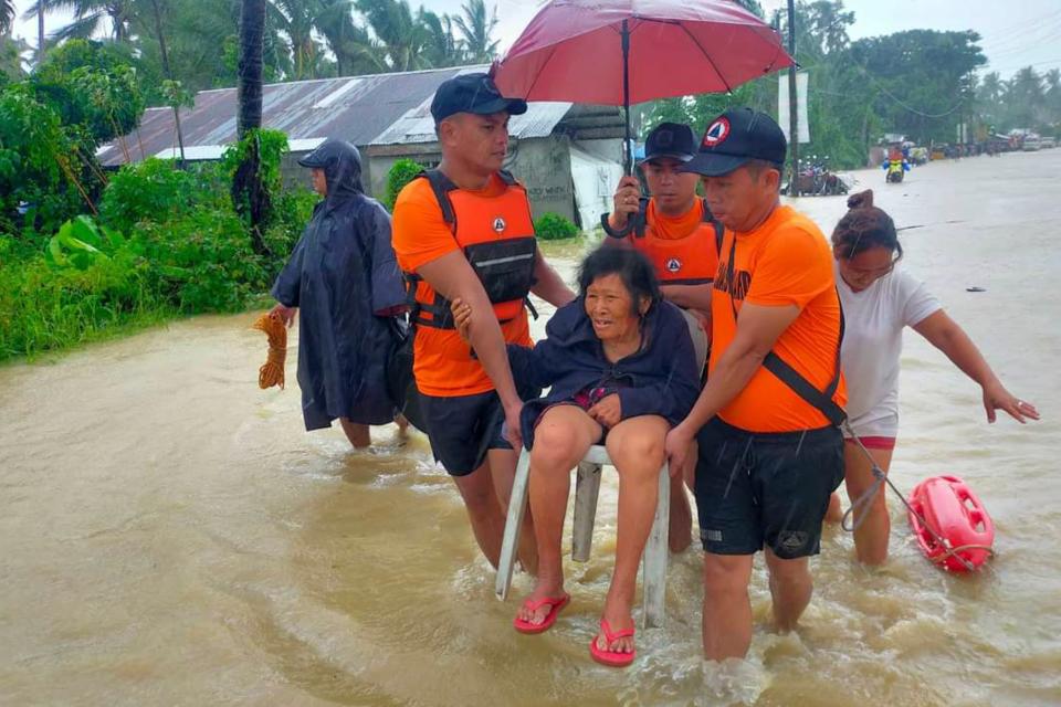 Rescuers evacuate residents from flood waters caused by Tropical Storm Nalgae in Hilongos, Leyte province, Philippines on Friday, Oct. 28, 2022, after flash floods and landslides set off by torrential rains left dozens of people dead. Many villagers are feared missing and buried in a deluge of rainwater, mud, rocks and trees.