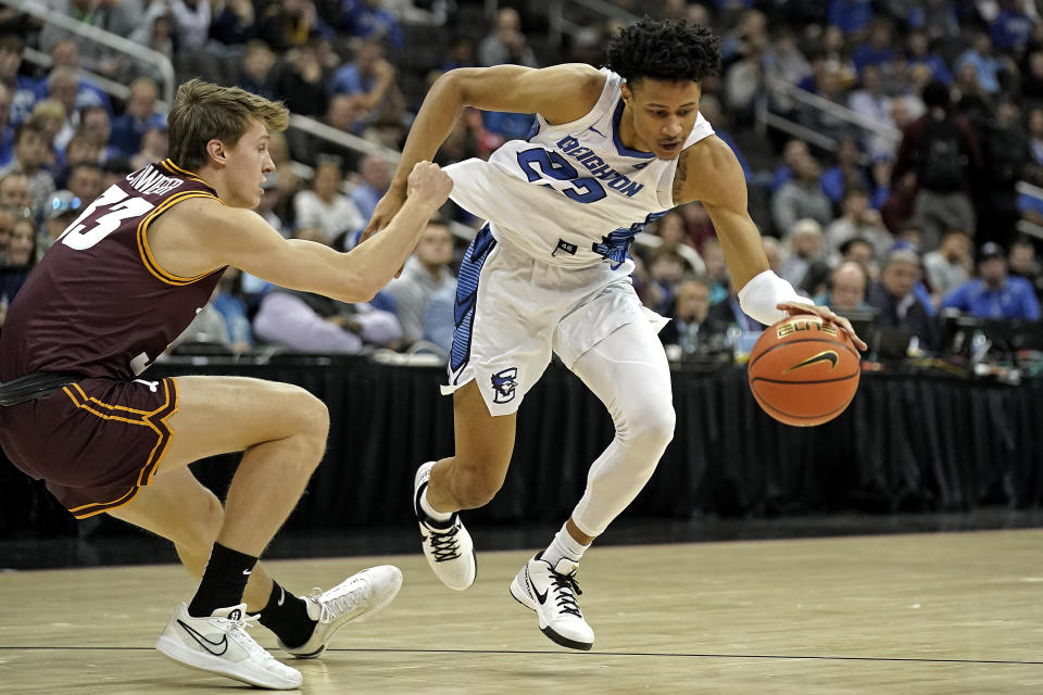 Loyola Chicago guard Ben Schwieger, left, tries to steal the ball from Creighton guard Trey Alexander (23) during the first half of an NCAA college basketball game Wednesday, Nov. 22, 2023, in Kansas City, Mo. (AP Photo/Charlie Riedel)