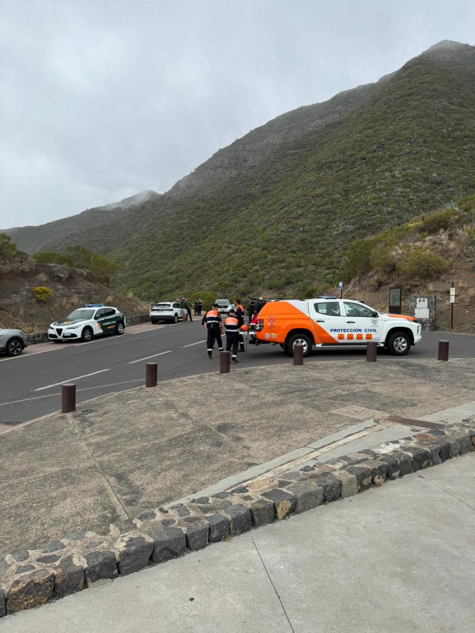 Vehicles in the road with a mountain backdrop