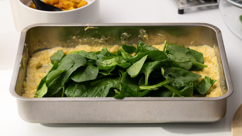 adding spinach to roasting tray