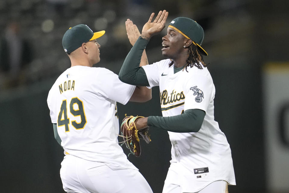 Oakland Athletics' Ryan Noda (49) and Lawrence Butler celebrate after the Athletics defeated the Pittsburgh Pirates in a baseball game in Oakland, Calif., Monday, April 29, 2024. (AP Photo/Jeff Chiu)