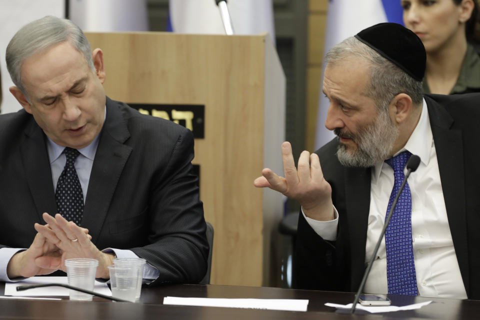 Israeli Prime Minister Benjamin Netanyahu listens to Israeli Interior Minister Aryeh Deri during a meeting with his nationalist allies and his Likud party members, at the Knesset, Israeli Parliament, in Jerusalem, Wednesday, March 4, 2020. (AP Photo/Sebastian Scheiner)