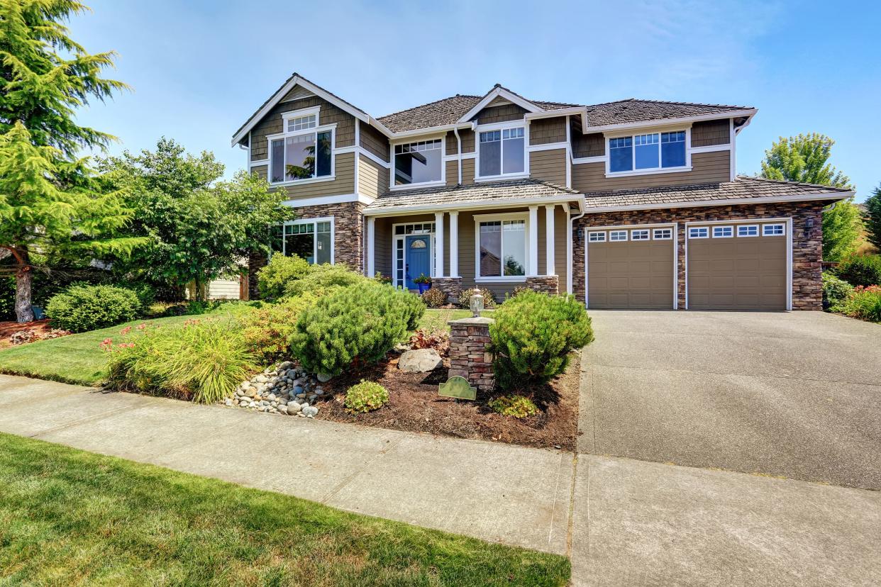 big house with yard and driveway in suburbia