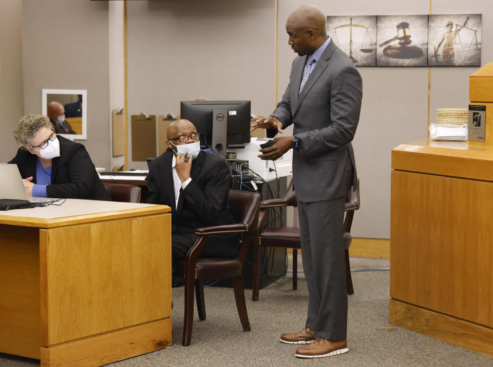 Defense attorney Kobby Warren, right, asks his client Billy Chemirmir, seated, if he understands the motions and language being sent to the jury after one juror is hanging up the deliberations in his capital murder trial at the Frank Crowley Courts Building in Dallas, Friday, Nov. 19, 2021. He was joined by private investigator Tonia Silva, left. Chemirmir, 48, faces life in prison without parole if convicted of capital murder for smothering Lu Thi Harris, 81, and stealing her jewelry. He is accused of killing at least 18 women in Dallas and Collin counties. (Tom Fox/The Dallas Morning News via AP, Pool)