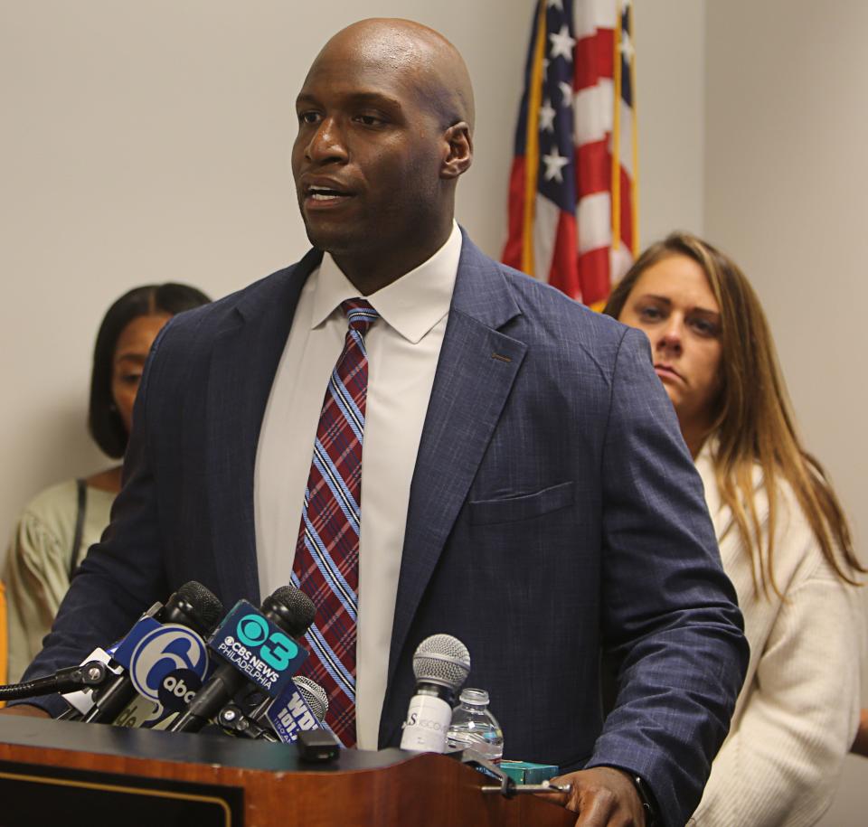 Attorney Chris Johnson (podium) speaks at a press conference two days after charges were filed against a Delaware State Police trooper in the attack of two teenagers in August.