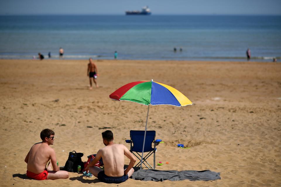 People enjoy the sunshine on the beach and in the sea at Botany Bay, near Margate, south east England on May 26, 2020, after some lockdown restrictions put in place to slow the spread of COVID-19 were partially eased earlier this month. - Britain's number of deaths "involving" the coronavirus has risen to 46,000, substantially higher than the 36,914 fatalities officially reported so far, according to a statistical update released Tuesday. The daily death tolls released in Britain only include fatalities that have been confirmed by a positive test. (Photo by Ben STANSALL / AFP) (Photo by BEN STANSALL/AFP via Getty Images)