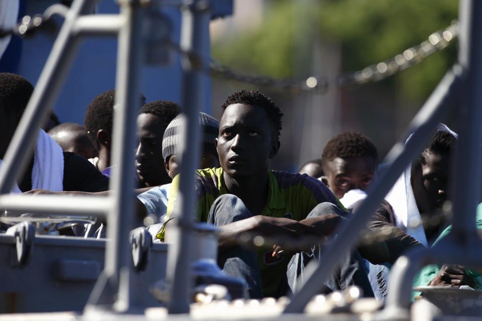 Rescued migrants sit on the deck of an Armed Forces of Malta patrol boat at the AFM Maritime Squadron base at Haywharf in Valletta's Marsamxett Harbour