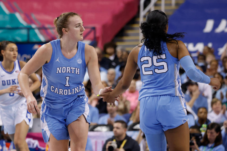 GREENSBORO, NC – MARCH 03: Alyssa Ustby #1 of the <a class="link " href="https://sports.yahoo.com/ncaaw/teams/n-carolina/" data-i13n="sec:content-canvas;subsec:anchor_text;elm:context_link" data-ylk="slk:North Carolina Tar Heels;sec:content-canvas;subsec:anchor_text;elm:context_link;itc:0">North Carolina Tar Heels</a> high fives teammate <a class="link " href="https://sports.yahoo.com/ncaaw/players/65130" data-i13n="sec:content-canvas;subsec:anchor_text;elm:context_link" data-ylk="slk:Deja Kelly;sec:content-canvas;subsec:anchor_text;elm:context_link;itc:0">Deja Kelly</a> #25 during the second half of their game against the <a class="link " href="https://sports.yahoo.com/ncaaw/teams/duke/" data-i13n="sec:content-canvas;subsec:anchor_text;elm:context_link" data-ylk="slk:Duke Blue Devils;sec:content-canvas;subsec:anchor_text;elm:context_link;itc:0">Duke Blue Devils</a> in the quarterfinals of the ACC Women’s Basketball Tournament at Greensboro Coliseum on March 3, 2023 in Greensboro, North Carolina. Duke won 44-40. (Photo by Lance King/Getty Images)