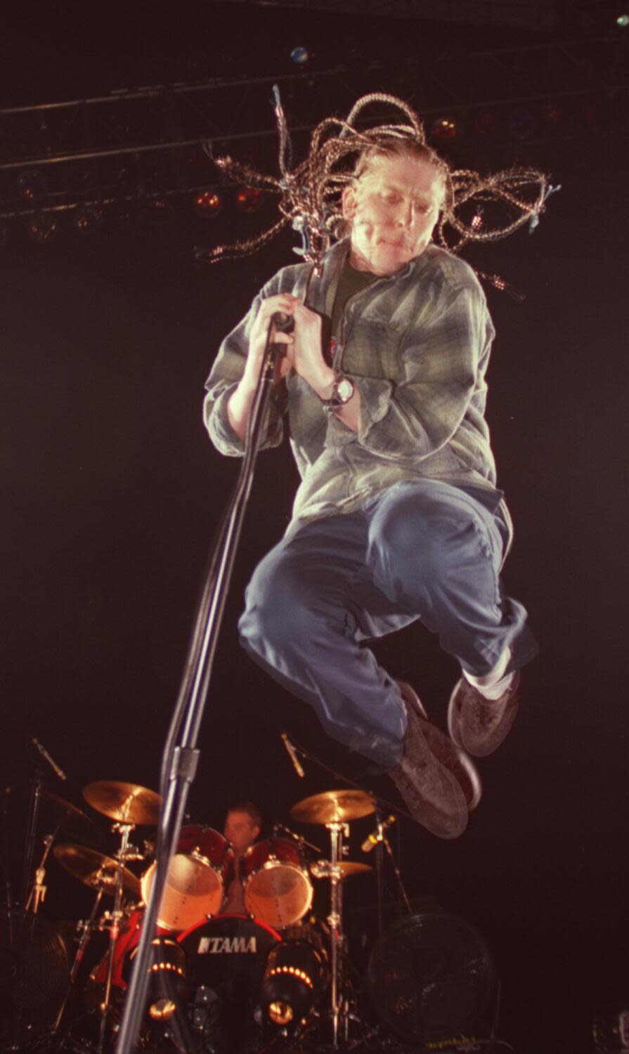 Man with braids jumping on stage