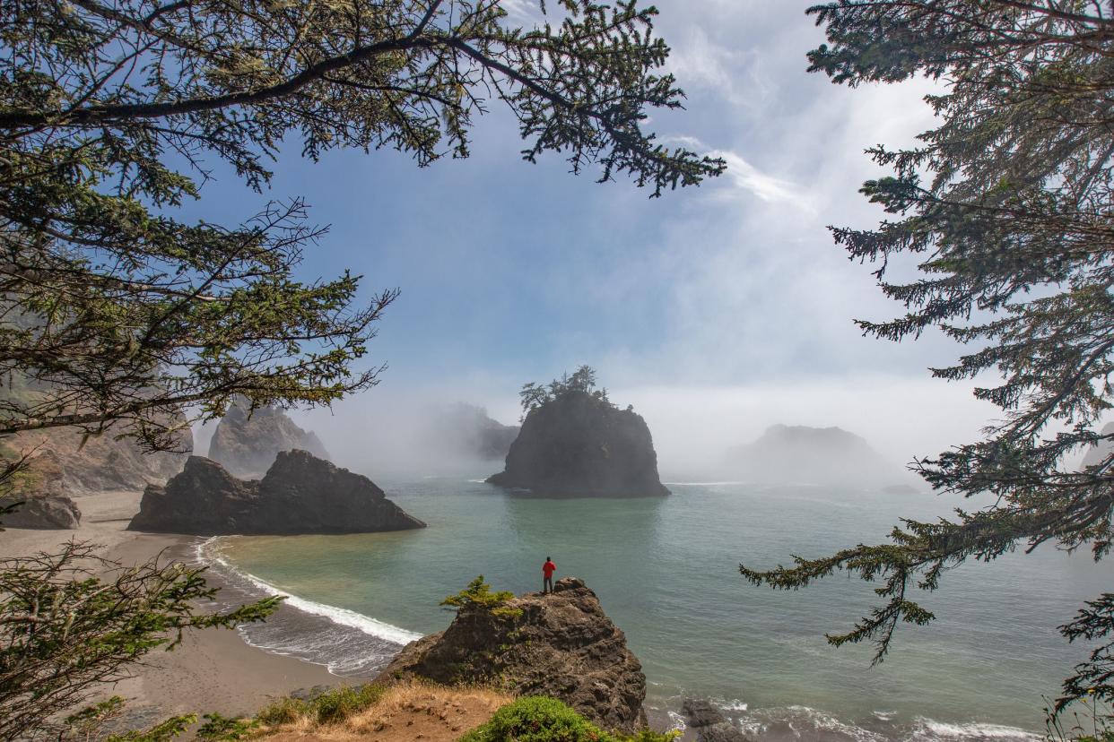 This is the picture of the travler standing on a rock at Secret Beach, Oregon, USA.