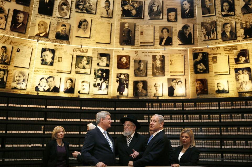 Canada's Prime Minister Stephen Harper (2nd L) and his wife Laureen (L), Israel's Prime Minister Benjamin Netanyahu (2nd R) and his wife Sara (R), listen to Yad Vashem Council Chairman Rabbi Israel Meir Lau (C) as they look at pictures of Jews killed in the Holocaust during a visit to the Hall of Names at Yad Vashem's Holocaust History Museum in Jerusalem January 21, 2014. REUTERS/Gali Tibbon/Pool (JERUSALEM - Tags: POLITICS)