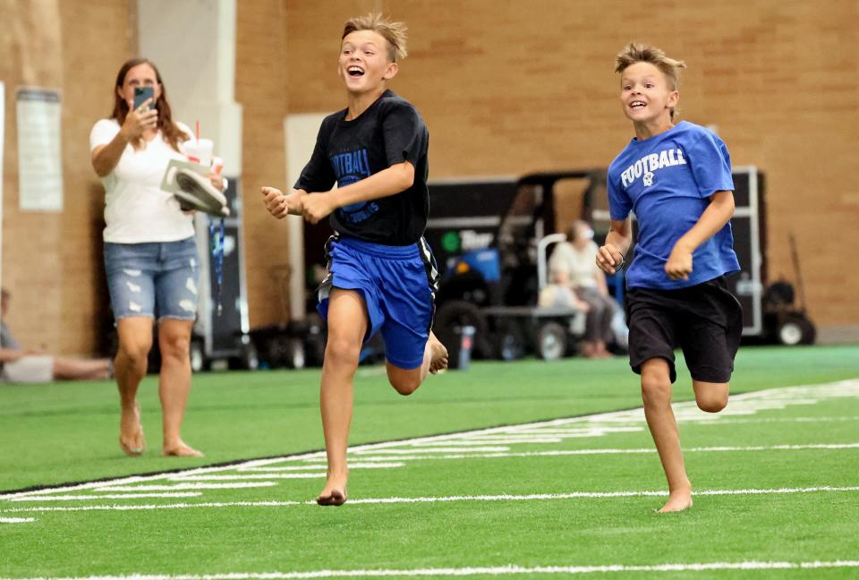 Brothers Jayce and Jackson Anderson race each other in the 40-yard dash inside the Indoor Practice Facility as BYU holds a party to celebrate their move into the Big 12 Conference with music, games and sports exhibits in Provo on Saturday, July 1, 2023. | Scott G Winterton, Deseret News