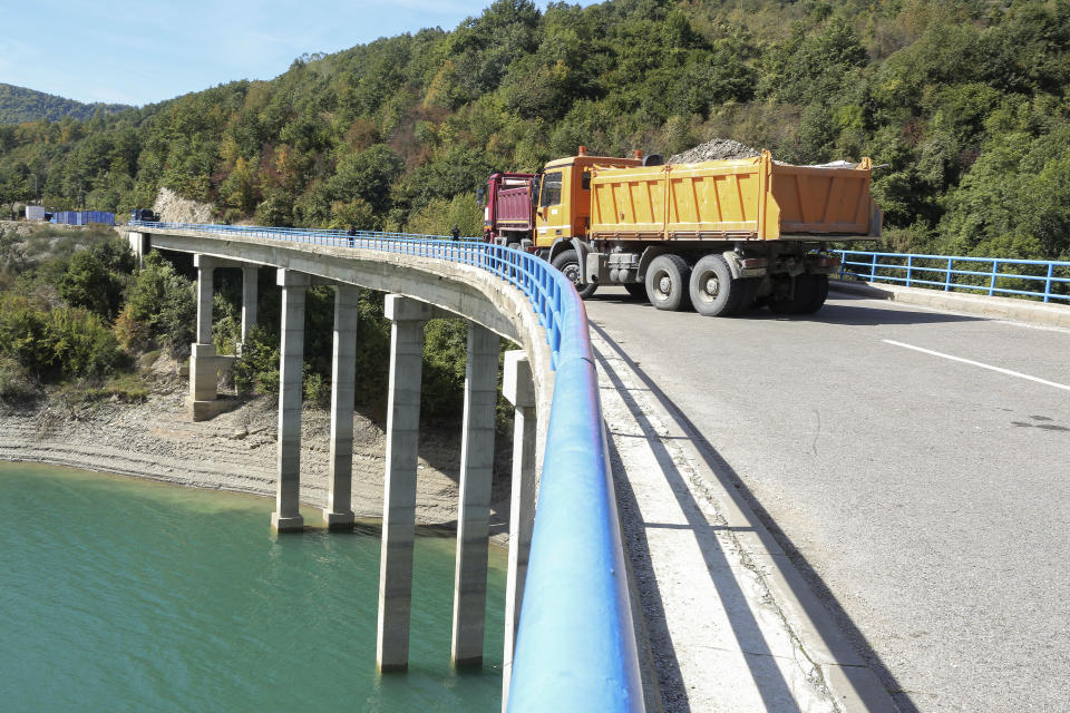 Trucks filled with stones barricade the bridge over Gazivode lake near the northern Kosovo border crossing of Brnjak on the fifth day of protest on Friday, Sept. 24, 2021. Ethnic Serbs in Kosovo have been blocking the border for a fifth straight day to protest a decision by Kosovo authorities to start removing Serbian license plates from cars entering the country, raising fears such incidents could unleash much deeper tensions between the two Balkan foes. (AP Photo/Visar Kryeziu)