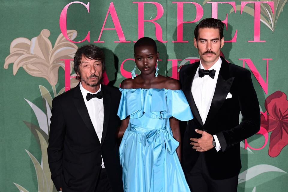 Italian fashion designer Pier Paolo Piccioli (L), South Sudanese model Adut Akech (C) and a guest arrive to attend the Green Carpet Fashion Awards