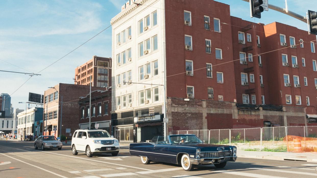 Kansas City, United States - May 6, 2016: On Friday afternoon a classic, blue Cadillac convertible car drives downtown past the traditional Midwestern American buildings.