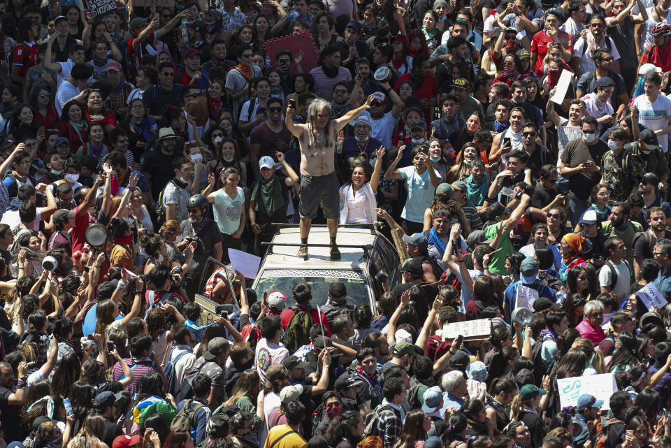 Anti-government demonstrators protest in Santiago, Chile, Tuesday, Oct. 22, 2019. Chile has been facing days of unrest, triggered by a relatively minor increase in subway fares. The protests have shaken a nation noted for economic stability over the past decades, which has seen steadily declining poverty despite persistent high rates of inequality. (AP Photo/Esteban Felix)