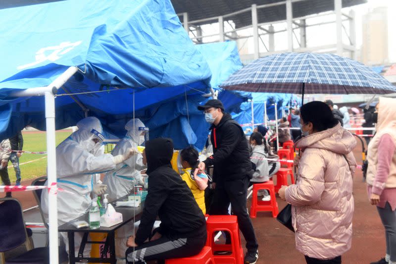 People line up at a nucleic acid testing site following cases of COVID-19 in Dongxing